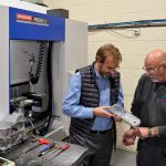 Two men inspecting machine results