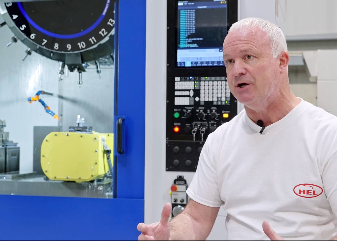 HEL Performance representative speaking on camera in front of a Brother CNC machining centre with multi-tool turret, providing a customer testimonial for Whitehouse Machine Tools